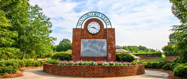 Shallowford Square clock tower with beautiful blooming flowers and lush trees