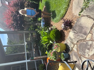 Kathy Swain stands in her beautiful summer yard.
