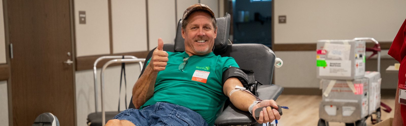 Man gives thumbs up while donating blood