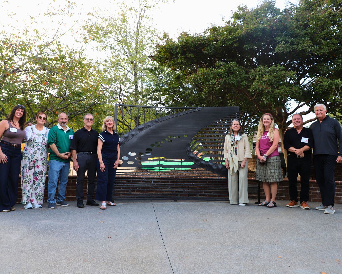 The Public Art Advisory Committee and Mayor of Lewisville, Mike Horn, pose with artists Paul and Pat Spainhour at the unveiling of the Shallow Ford relief sculpture in Shallowford Square.
