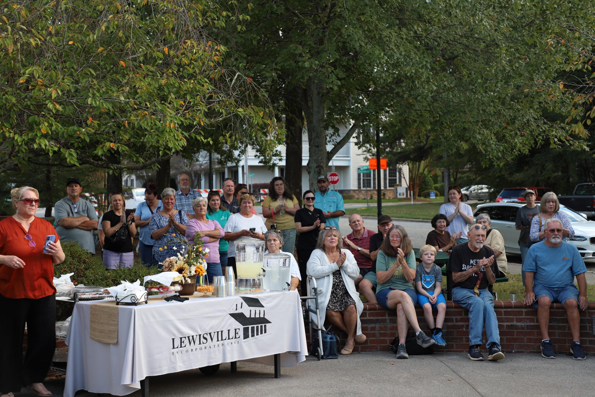 A group of people surround the unveiling at Shallowford Square of the new relief sculpture.